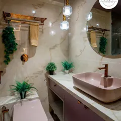 This bathroom combines soft pink tones with elegant marble-finish tiles. The pendant lights, rose gold fixtures, and floating vanity create a chic and modern aesthetic.