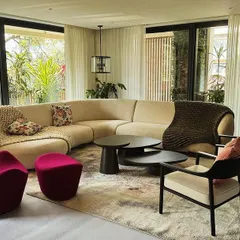 We designed this living space around a custom curved sofa that encourages conversation, complemented by a sculptural magenta lounge chair. The furniture works together to create a room that is open, connected to the outdoors, and full of personality.