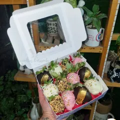 A beautiful box of chocolate-dipped strawberries. This assortment features strawberries dipped in dark, white, and pink chocolate, with elegant toppings like gold leaf and crunchy nuts.