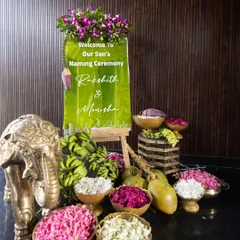 Another view of the elegant welcome station. The reflection on the glossy floor doubles the beauty of the floral arrangement, the custom sign, and the traditional brass elements.