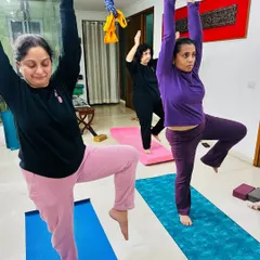 Finding balance together. Our students support each other's energy as they practice a standing balancing pose, building both physical stability and mental focus.