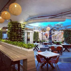 Greening up an office cafeteria by wrapping structural pillars in vertical gardens. This not only hides the concrete but also improves air quality and adds a refreshing, natural element to the employee break area.