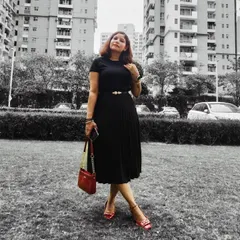 An all-black outfit is my personal favorite for its timeless elegance. Here, I’ve styled a pleated midi skirt and top with a statement belt and a pop of red from the bag and shoes, creating a sophisticated look perfect for any occasion.