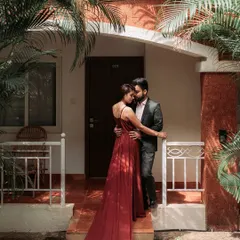 An elegant and passionate portrait at a Goan resort. The bride's deep red gown and the lush tropical foliage create a rich, romantic atmosphere, perfect for a sophisticated pre-wedding look.