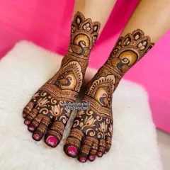 Don't forget your feet! This bridal foot mehandi features bold peacock motifs, a popular choice for brides, framed by delicate floral patterns. I ensure the design is symmetrical and beautifully adorns the feet, completing your head-to-toe bridal look.