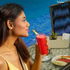 A guest enjoys a refreshing, vibrant cocktail by the pool at Aqua. Our drinks are ingredient-driven and contemporary, designed to perfectly match the relaxed, stylish vibe of our poolside bar.