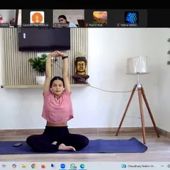 An instructor demonstrates a seated arm stretch during our Stress Management Yoga Workshop. Simple movements like these can be done at your desk to release tension in the shoulders and upper back.