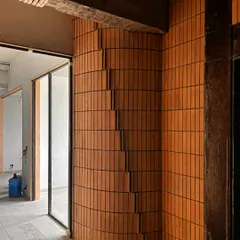 A detail of the "pixelated" brickwork, with sections of brick stepping in and out to create a dynamic, three-dimensional surface.