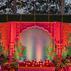 For a Haldi or Mehndi, I love to play with vibrant traditions. This stage is a burst of joyful color, combining fuchsia, marigold, and intricate Rajasthani-inspired architecture to create a festive and photo-perfect setting.