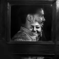A moody and artistic black and white reflection shot, capturing the couple's profiles in a unique composition.