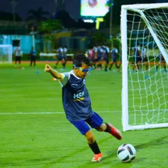 A young player practices his shooting, aiming for the goal with focus and determination.