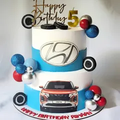 This two-tier cake was designed for a car enthusiast, featuring the Hyundai logo and an edible image of the Creta. It's a great example of incorporating brand elements into a personal celebration cake.