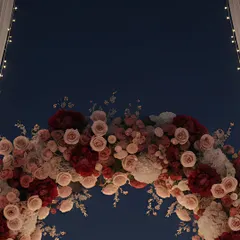 A close-up of a custom floral arch, crafted with a mix of lush red, pink, and white roses and peonies. This element adds a soft, natural beauty that contrasts perfectly with the city lights.