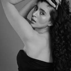 A more dramatic, moody shot showcasing long, beautiful curls. This black and white image highlights the texture and shape of the hair, creating a powerful and artistic portrait.