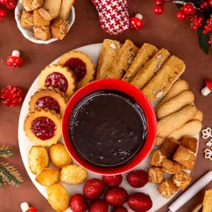 A Christmas-themed chocolate fondue platter. The overhead shot captures the abundance of treats, from strawberries and cookies to marshmallows, all ready for dipping.