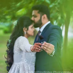 A detailed shot focusing on the engagement ring, with the couple sharing a tender moment in the background. It's a perfect way to announce your engagement.