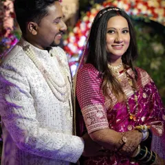 A happy couple at their reception. The bride's makeup is glamorous yet soft, with dewy skin and bold eyes that make her shine.