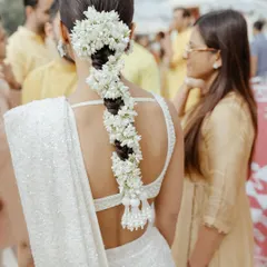A detailed shot of a traditional South Indian bridal braid, beautifully decorated with fresh jasmine flowers (gajra). This style is timeless, fragrant, and incredibly photogenic.