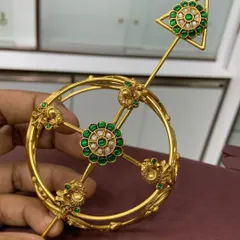 My designer bun cover, or 'juda' pin, is a perfect hair accessory for brides. This gold-plated piece features a beautiful floral motif with green stones and pearls, and the pin ensures it stays securely in place.