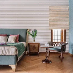 Here, we used a calm, muted color palette and natural materials to create a peaceful atmosphere. The herringbone wooden flooring adds warmth, while the traditional-style chair and side table provide a charming space for reading by the window.
