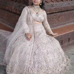 A beautiful outdoor shot of the ivory lehenga, showing how the intricate silver work shines in natural light. A great choice for a day event.