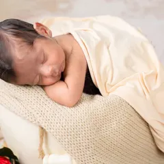 Capturing the tiny details is so important. This close-up shot focuses on the baby's peaceful, sleeping face and tiny hands, highlighting the delicate features you'll want to remember forever.