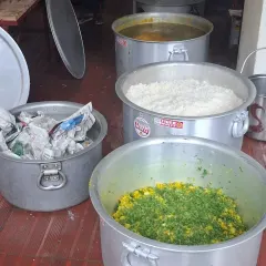 Food preparation for the bhandara. You can see large vessels of rice, dal, and vegetables getting ready to be served.