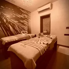 Our elegant couples therapy room, complete with a crystal chandelier and serene wall art, provides a luxurious and private space for you and a partner to unwind together with our signature massage treatments.