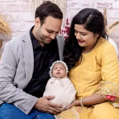 A heartwarming portrait of new parents admiring their sleeping baby. This photo captures the quiet, loving atmosphere of a family just beginning their journey together.