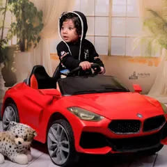 Another angle of the little driver in his red convertible. The soft, studio-lit background ensures that the baby and the car are the stars of the photo.