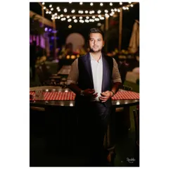 A classic look for an evening dinner. The groom wears a custom-designed navy waistcoat over a crisp white shirt, a timeless combination that is both sharp and relaxed.