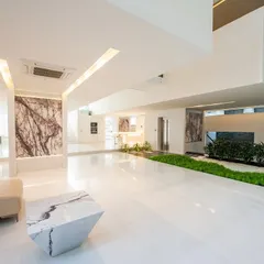 The guest level at the Neeti Residence. This expansive, open-plan area features polished white floors and book-matched marble panels, with an indoor garden blurring the line between interior and exterior.