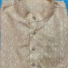 A close-up of a folded beige kurta, showcasing the texture of the self-embroidered fabric and the neat construction of the collar and placket. This is a classic color suitable for both day and night events.