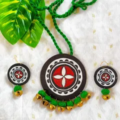 A closer look at the green and red mandala pendant set. The hand-painted details and the brass ghungroos are clearly visible, showcasing the craftsmanship that goes into each piece.