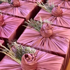 Another look at the elegance of fabric wrapping. The soft pleats of the dusty rose fabric, combined with a delicate floral arrangement, transform a simple box into a work of art, perfect for weddings or luxury events.