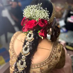 A detailed look at a traditional South Indian bridal hairstyle. I created an intricate braid, beautifully decorated with fresh red roses, baby's breath, and elaborate hair jewellery for a timeless and elegant finish.