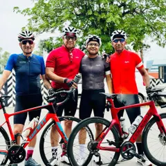 Four members of our cycling family posing together. The mix of red and blue jerseys shows the individual style within our unified team.