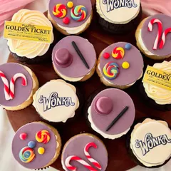 A full set of Willy Wonka inspired cupcakes. The designs feature iconic elements made from fondant like candy canes and lollipops, alongside edible prints of the Wonka logo and a Golden Ticket, all arranged on vanilla and chocolate bases.