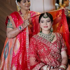 A beautiful moment between a bride and her mother. Her classic red lehenga is paired with timeless makeup, creating a picture-perfect memory.
