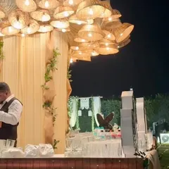 A rustic bar setup featuring a unique chandelier made from woven baskets, creating a warm and inviting focal point for the event.