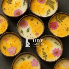A top-down view of the coconut shell candles, showing the beautiful arrangement of dried flowers on the wax.