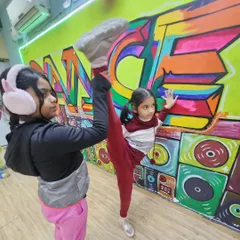 Flexibility is a key part of our training. Here, one student helps another with a standing split stretch, showcasing the supportive environment I foster in my classes.