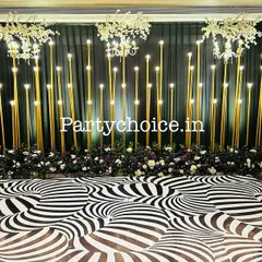 We designed this complete sangeet setup with a custom dance floor. The black and white optical illusion pattern on the floor contrasts with the warm, illuminated gold pillars of the stage backdrop, inviting guests to dance the night away.