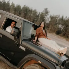 Relaxing on their Mahindra Thar, enjoying the view. This shot combines their love for adventure with a cool, laid-back vibe.