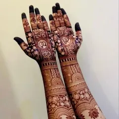 A beautiful example of personalized traditional mehndi. This design incorporates engagement rings and the couple's initials 'V' and 'R' into the palms, surrounded by delicate floral and paisley patterns.