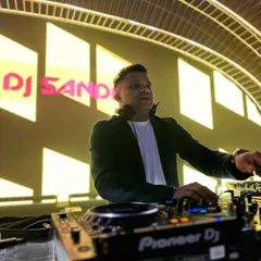 In the zone during a destination wedding in Vietnam. This shot captures my focus at the Pioneer DJ console, with my name lit up in the background, showcasing the professionalism I bring to every international gig.