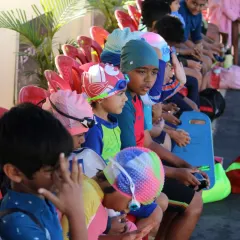Our young water warriors, kitted out in their swim caps and gear, listen intently for instructions from their coach.