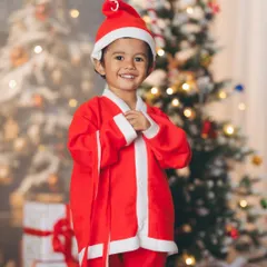Dressed as Santa Claus in front of a softly lit Christmas tree. This portrait captures the classic holiday spirit, focusing on the child's happy expression and festive attire.