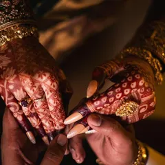 A beautiful shot of the couple holding hands, where the bride's dark mehendi stain stands out against the groom's hand.