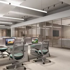 This view of the open-plan workstation area at Hamdard HQ shows how we use glass partitions and a neutral color palette to create a bright and airy environment. The layout is designed to facilitate both focused work and easy circulation.